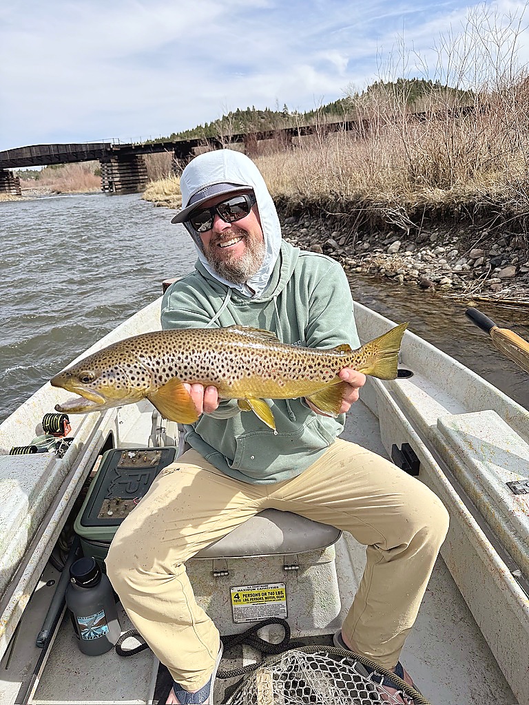 Jason wade fishing near a railroad bridge on the Clark Fork River